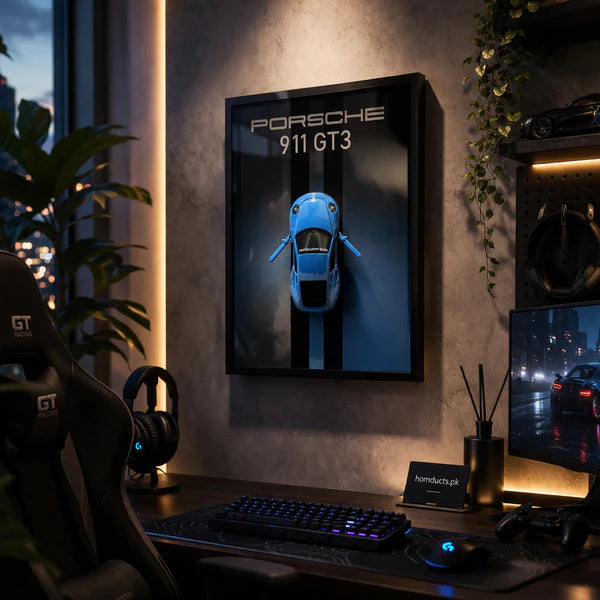 Luxury 3D Car Frame Wall Art With Mini Sports Car - Porsche. Gaming setup with Porsche 911 GT3 poster on a wall, desk with computer equipment, and cityscape view.